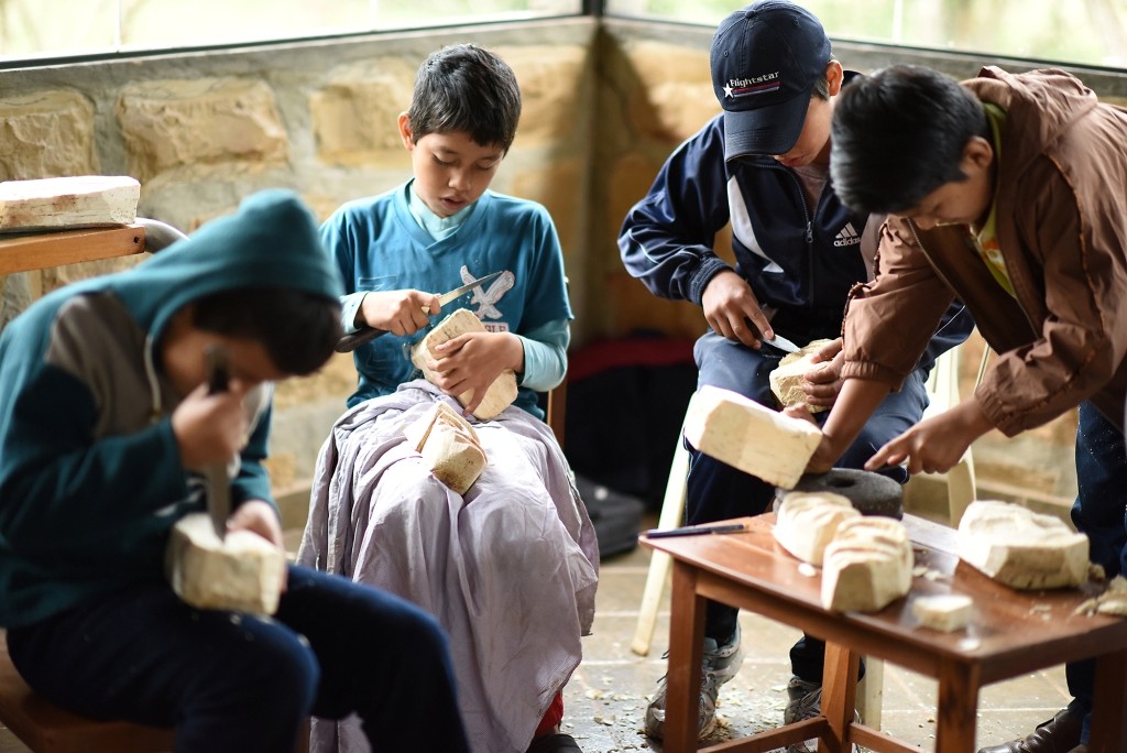 Durante su aprendizaje, los pequeños artesanos utilizaron pedazos de raíz de toco del tamaño de una cabeza, que limpiaron con un cuchillo y poco a poco le dieron forma de un rostro.